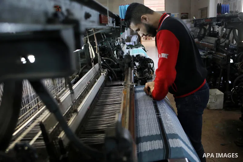 A Palestinian man works at a Keffiyeh textile factory in the West Bank City of Hebron, on November 22, 2021. Keffiyeh is black-and-white chequered scarf is a traditional Arabian headdress. Photo by Mamoun Wazwaz