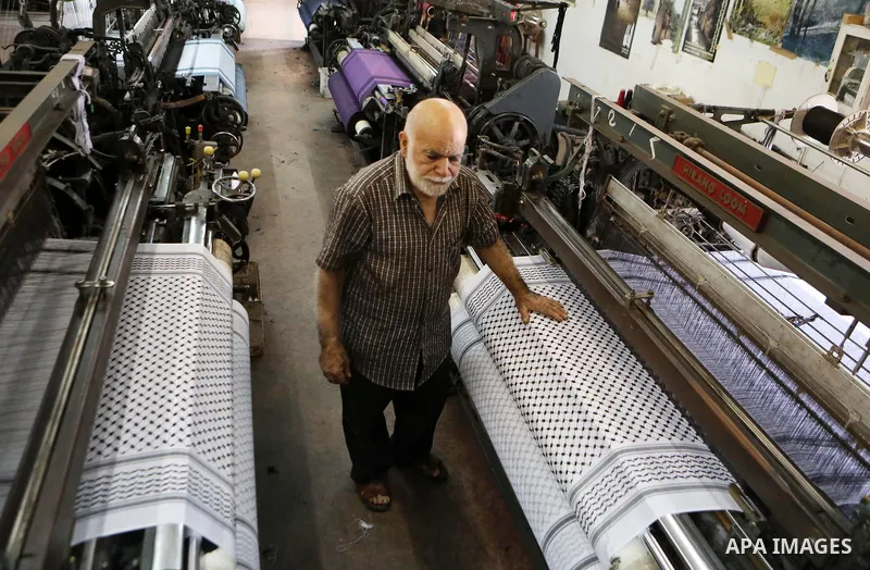 A Palestinian man works at a Keffiyeh textile factory in the West Bank City of Hebron, on November 22, 2021. Keffiyeh is black-and-white chequered scarf is a traditional Arabian headdress. Photo by Mamoun Wazwaz