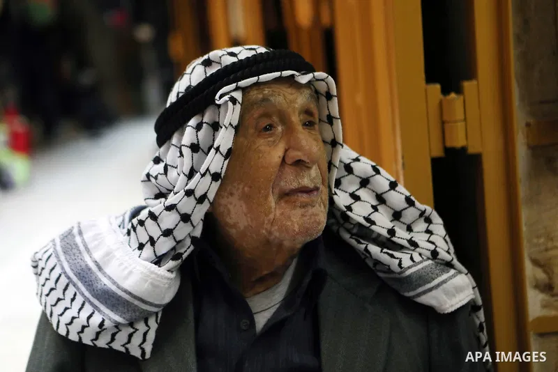 A Palestinian man wearing Keffiyeh walks at a street in the West Bank City of Hebron, on November 22, 2021. Keffiyeh is black-and-white chequered scarf is a traditional Arabian headdress. Photo by Mamoun Wazwaz