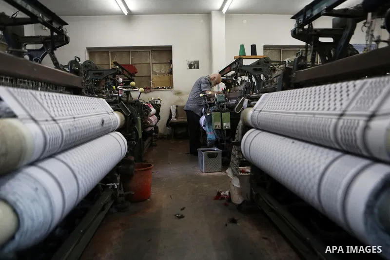 A Palestinian man works at a Keffiyeh textile factory in the West Bank City of Hebron, on November 22, 2021. Keffiyeh is black-and-white chequered scarf is a traditional Arabian headdress. Photo by Mamoun Wazwaz