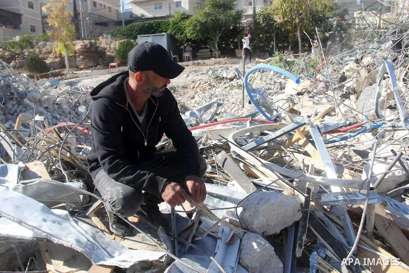 A Palestinian man inspect the debris his house in the village of Sur Baher which sits on either side of the Israeli barrier in East Jerusalem and the Israeli-occupied West Bank November 23, 2021. Photo by Mahfouz Abu Tur...