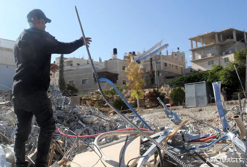 A Palestinian man inspect the debris his house in the village of Sur Baher which sits on either side of the Israeli barrier in East Jerusalem and the Israeli-occupied West Bank November 23, 2021. Photo by Mahfouz Abu Tur...