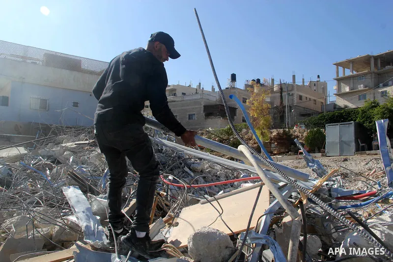 A Palestinian man inspect the debris his house in the village of Sur Baher which sits on either side of the Israeli barrier in East Jerusalem and the Israeli-occupied West Bank November 23, 2021. Photo by Mahfouz Abu Tur...