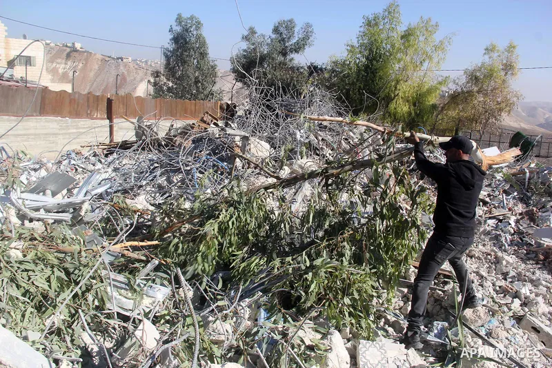 A Palestinian man inspect the debris his house in the village of Sur Baher which sits on either side of the Israeli barrier in East Jerusalem and the Israeli-occupied West Bank November 23, 2021. Photo by Mahfouz Abu Tur...