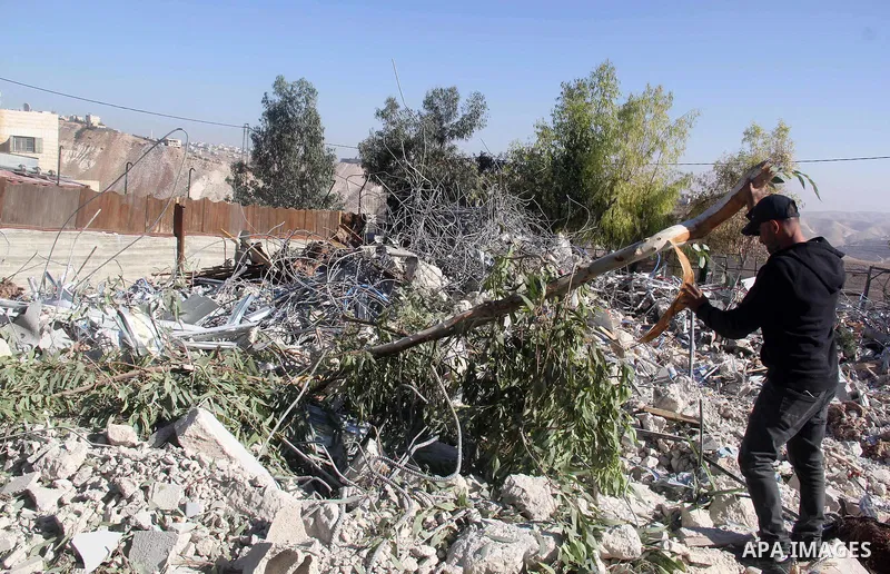 A Palestinian man inspect the debris his house in the village of Sur Baher which sits on either side of the Israeli barrier in East Jerusalem and the Israeli-occupied West Bank November 23, 2021. Photo by Mahfouz Abu Tur...