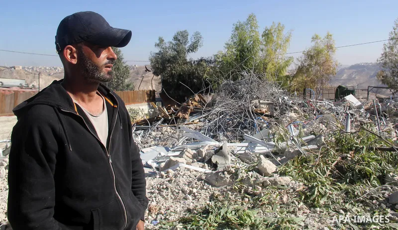 A Palestinian man inspect the debris his house in the village of Sur Baher which sits on either side of the Israeli barrier in East Jerusalem and the Israeli-occupied West Bank November 23, 2021. Photo by Mahfouz Abu Tur...