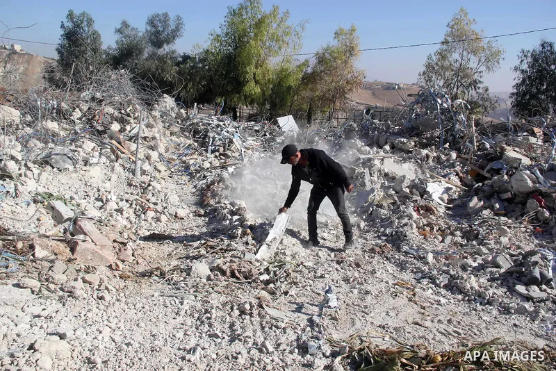 A Palestinian man inspect the debris his house in the village of Sur Baher which sits on either side of the Israeli barrier in East Jerusalem and the Israeli-occupied West Bank November 23, 2021. Photo by Mahfouz Abu Tur...