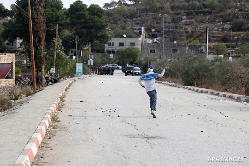 Israeli forces and Palestinian demonstrators clash in the village of al-Lubban al-Sharqiya in the Israeli-occupied West Bank on November 25, 2021. Photo by Wajed Nobani