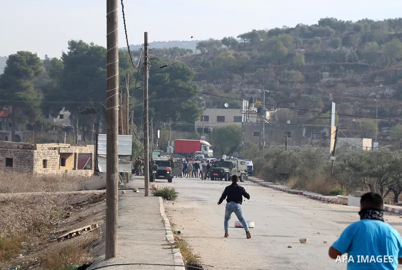Israeli forces and Palestinian demonstrators clash in the village of al-Lubban al-Sharqiya in the Israeli-occupied West Bank on November 25, 2021. Photo by Wajed Nobani