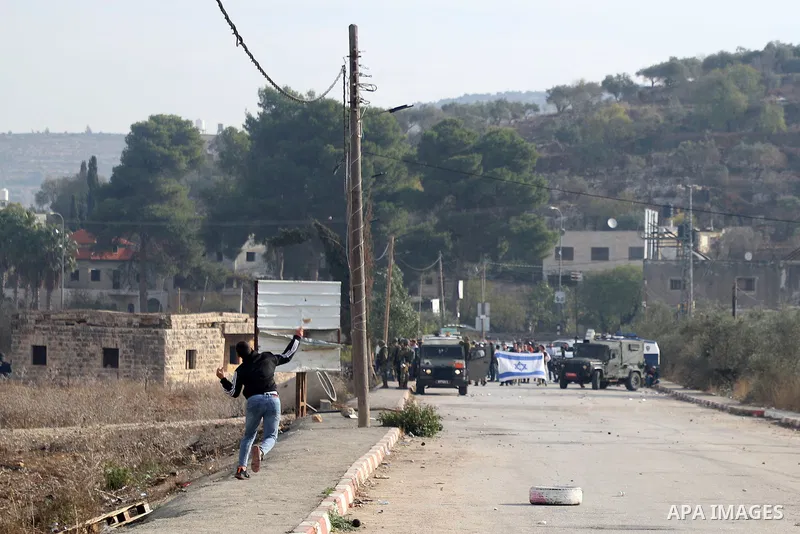 Israeli forces and Palestinian demonstrators clash in the village of al-Lubban al-Sharqiya in the Israeli-occupied West Bank on November 25, 2021. Photo by Wajed Nobani