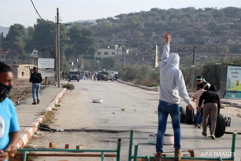 Israeli forces and Palestinian demonstrators clash in the village of al-Lubban al-Sharqiya in the Israeli-occupied West Bank on November 25, 2021. Photo by Wajed Nobani