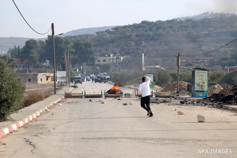Israeli forces and Palestinian demonstrators clash in the village of al-Lubban al-Sharqiya in the Israeli-occupied West Bank on November 25, 2021. Photo by Wajed Nobani