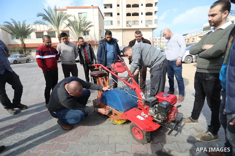 Palestinian engineers invent a street sweeping machine, in Deir al-Balah, in the center of Gaza strip, on November 25, 2021. Engineers invented a machine for sweeping and cleaning streets to facilitate the work of cleane...