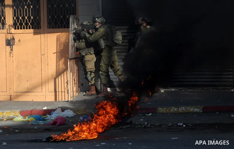 Palestinian protesters and Israeli security forces clash in the West Bank city of Hebron on November 26, 2021. Photo by Mamoun Wazwaz
