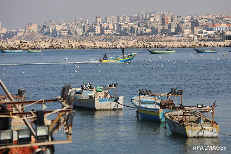 Palestinian fishermen work on the shore of the Mediterranean Sea, in Gaza city, on November 27, 2021. The Israeli authorities released the two detained fishermen at Erez crossing, north of Gaza, and seized their boat. Is...
