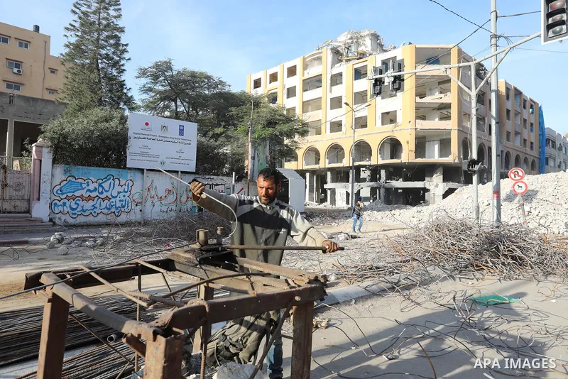 Palestinian workers remove the rubbles of al-Jawhara tower which was hit by Israeli strikes during the recent 11-day conflict between Israel and Hamas on May, in Gaza city on November 25, 2021. People and businesses in t...