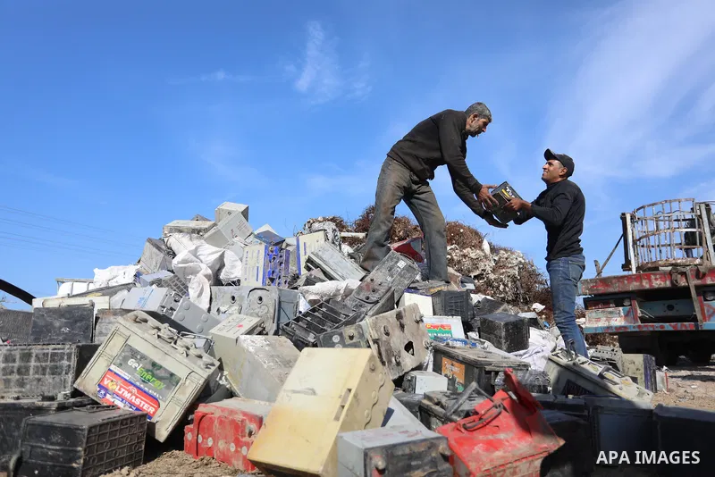 A Palestinian worker sorts through electronic waste such as batteries, a popular product in the midst of Gaza’s electricity crisis, after Israeli authorities prevented the export of 25,000 tons of damaged batteries, in J...