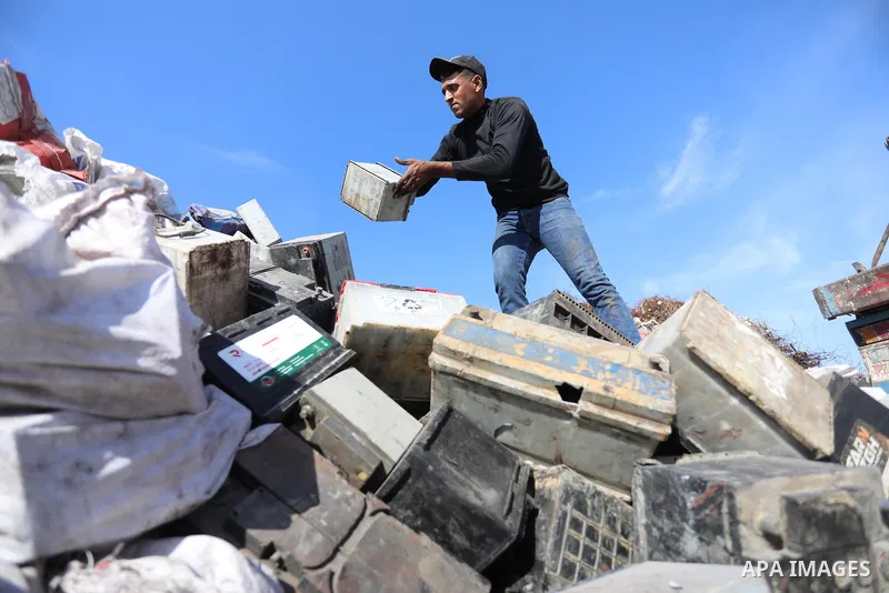 A Palestinian worker sorts through electronic waste such as batteries, a popular product in the midst of Gaza’s electricity crisis, after Israeli authorities prevented the export of 25,000 tons of damaged batteries, in J...