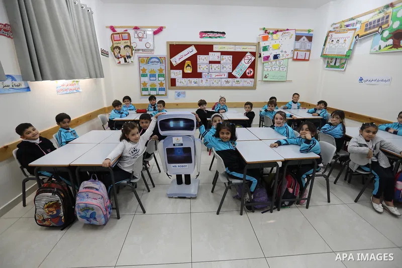 Palestinian students interact with a locally-made educational robot during a science class at a private school in Gaza City on November 30, 2021. Photo by Ashraf Amra