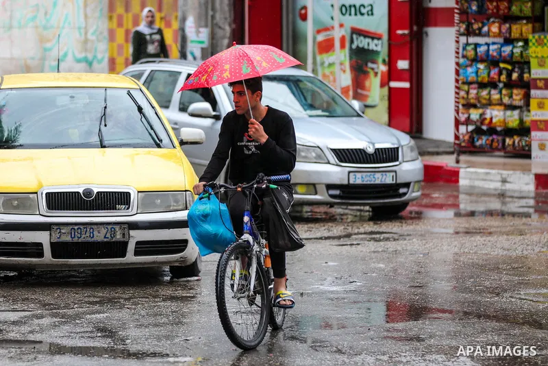 Palestinians show as they in their daily lifes during a rainy day, in Gaza City December 01, 2021. A low-pressure front is expected to affect Palestine today, thus weather conditions are set to be partly cloudy to cloudy...
