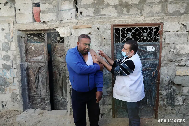 Palestinian youths take part in a campaign to encourage people to get vaccinated against COVID-19, in Gaza city on December 2, 2021. Three people have died of coronavirus in the Gaza Strip and one person in the West Bank...