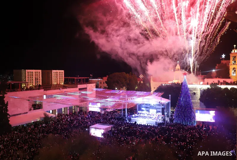 Palestinians light Christmas tree in Manger Square outside the Church of the Nativity in the West Bank city of Bethlehem on December 4, 2021. Christmas is an annual festival commemorating the birth of Jesus Christ, obser...