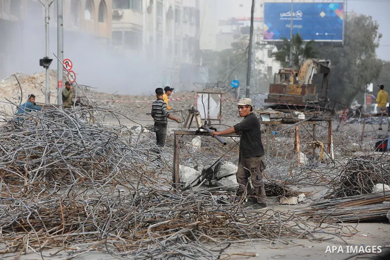 Palestinian workers remove the rubbles of al-Jawhara tower which was hit by Israeli strikes during the recent 11-day conflict between Israel and Hamas on May, in Gaza city on December 06, 2021. People and businesses in t...