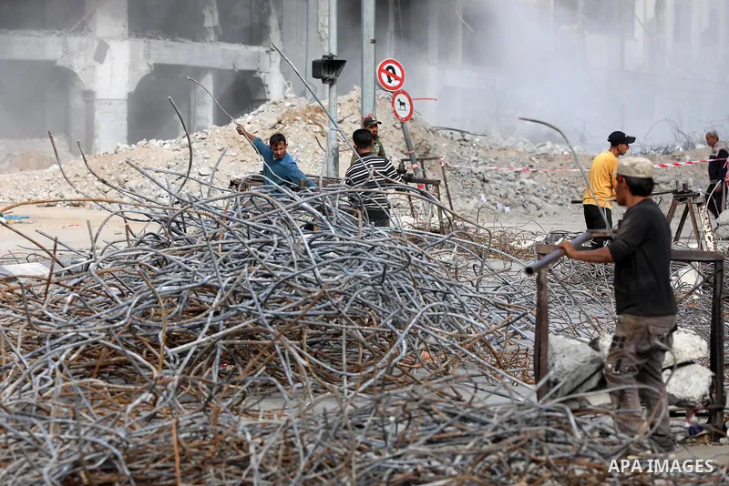 Palestinian workers remove the rubbles of al-Jawhara tower which was hit by Israeli strikes during the recent 11-day conflict between Israel and Hamas on May, in Gaza city on December 06, 2021. People and businesses in t...