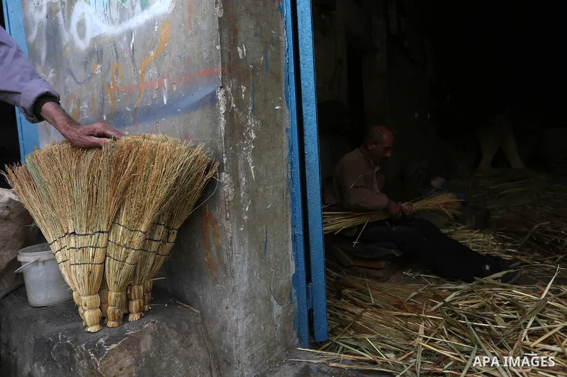 Palestinian man makes traditional straw brooms at his workshop in Roujeeb village, east of the West Bank city of Nablus, on December 8, 2021. A broom (also known in some forms as a broomstick) is a cleaning tool consisti...