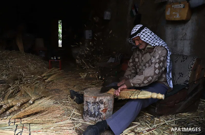 Palestinian man makes traditional straw brooms at his workshop in Roujeeb village, east of the West Bank city of Nablus, on December 8, 2021. A broom (also known in some forms as a broomstick) is a cleaning tool consisti...