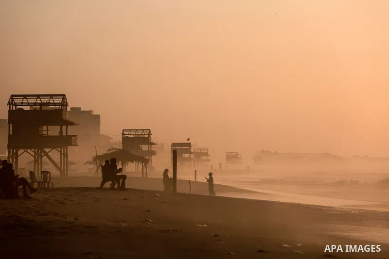 Palestinians walk during stormy weather along a beach by the Mediterranean Sea in Gaza City on December 9, 202. Photo by Mohammed Dahman