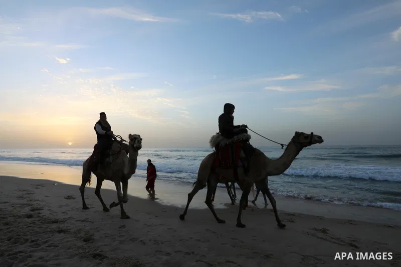 Palestinians enjoy their time during sunset along a beach by the Mediterranean Sea in Gaza City on December 10, 2021. Photo by Ashraf Amra