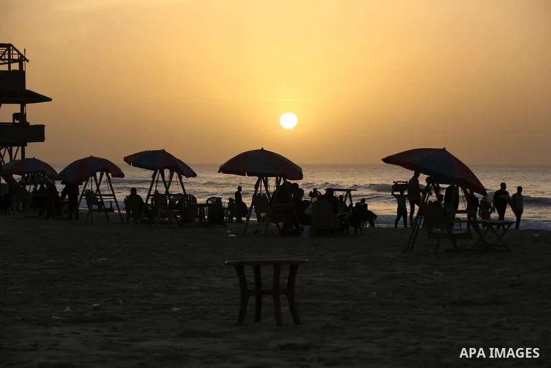 Palestinians enjoy their time during sunset along a beach by the Mediterranean Sea in Gaza City on December 10, 2021. Photo by Ashraf Amra