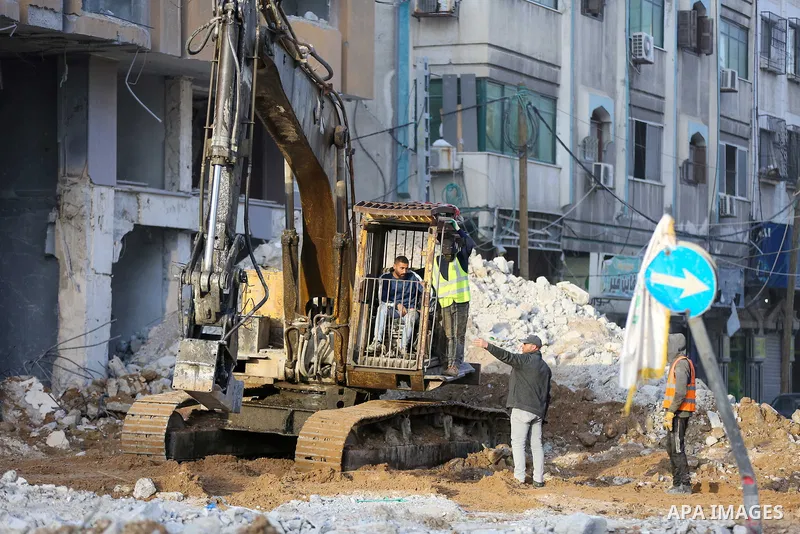 Palestinian workers remove the rubbles of al-Jawhara tower which was hit by Israeli strikes during the recent 11-day conflict between Israel and Hamas on May, in Gaza city on December 19, 2021. Photo by Atia Darwish
