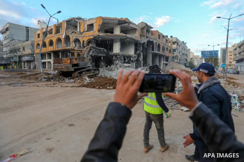 Palestinian workers remove the rubbles of al-Jawhara tower which was hit by Israeli strikes during the recent 11-day conflict between Israel and Hamas on May, in Gaza city on December 19, 2021. Photo by Atia Darwish