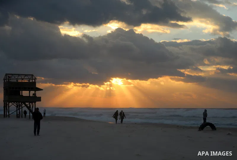 Palestinians walk at the beach of Gaza sea during stormy weather on December 20, 2021. Photo by Salam Yasser