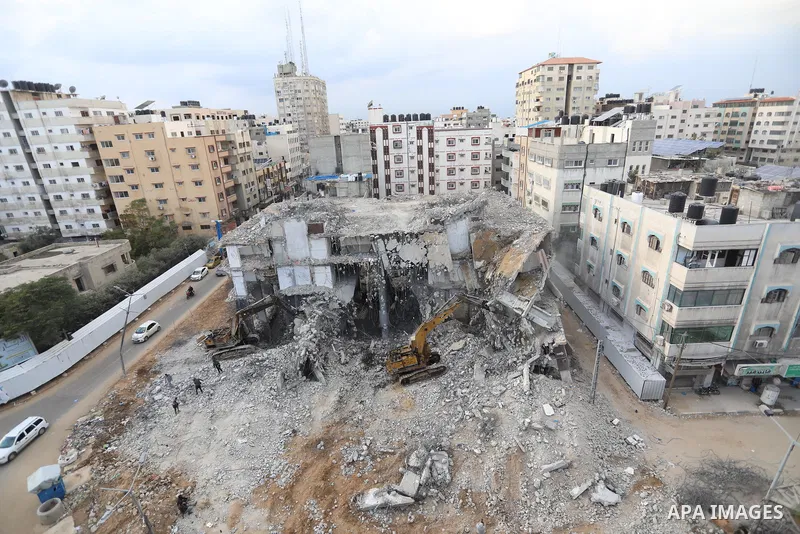Palestinian workers remove the rubbles of al-Jawhara tower which was hit by Israeli strikes during the recent 11-day conflict between Israel and Hamas on May, on December 22, 2021. Photo by Ashraf Amra