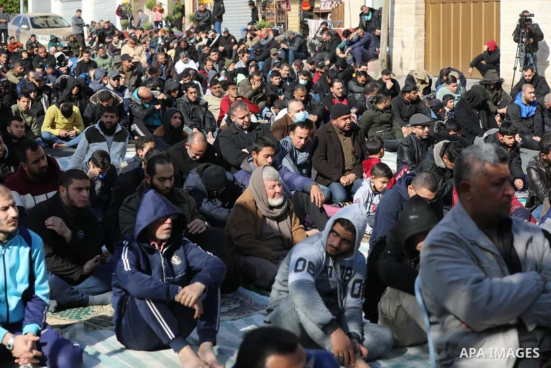 Palestinians attend Friday prayer in solidarity with Palestinian prisoners in Israeli jails, in front of Red Cross office in Gaza city, on December 24, 2021. Photo by Ashraf Amra
