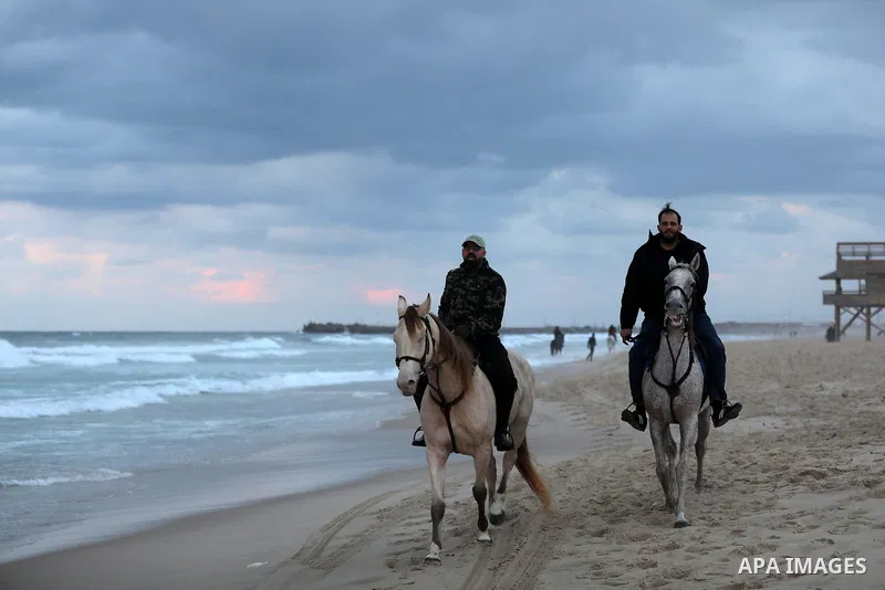 Palestinians enjoy their time on the beach of Gaza sea during sunset on December 24, 2021. The beach is one of the few open public spaces in this densely populated city. Photo by Ashraf Amra