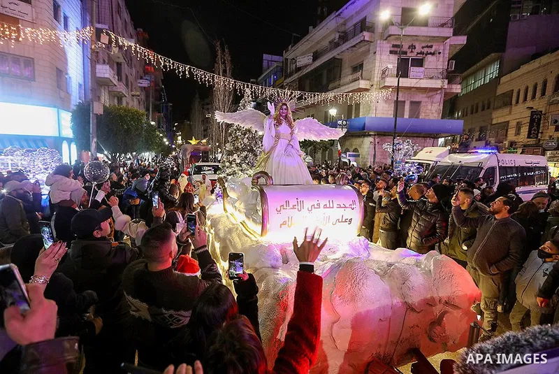 Palestinians watch the Christmas convoy during Christmas celebrationsin West Bank city of Ramallah, on December 2021. Photo by Hudhayfa Sorour \WAFA