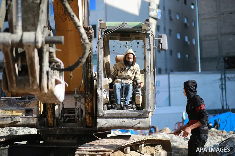 Palestinian workers remove the rubbles of al-Jawhara tower which was hit by Israeli strikes during the recent 11-day conflict between Israel and Hamas on May, on December 26, 2021. Photo by Bashar Taleb