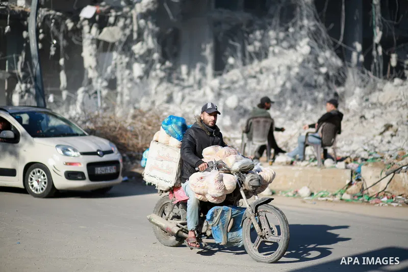 Palestinian workers remove the rubbles of al-Jawhara tower which was hit by Israeli strikes during the recent 11-day conflict between Israel and Hamas on May, on December 26, 2021. Photo by Bashar Taleb