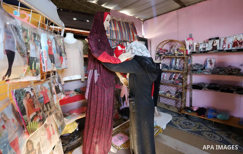 Palestinian woman Shahd Jouda, 30, displays clothes in a small shop on the roof of her family's home in Rafah in the southern of Gaza Strip, on December 29, 2021. The economy in Gaza has been in recession since May’s esc...