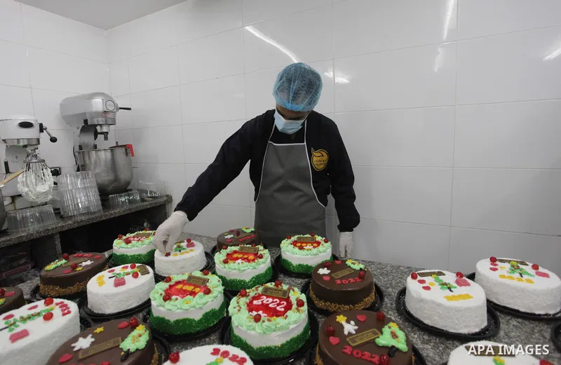 Palestinian chefs put final touches on cakes which portrays the new year number "2022", in Gaza city on December 30, 2021. Gazans hope for peace, prosperity in 2022 after the recent 11-day conflict between Israel and Ham...