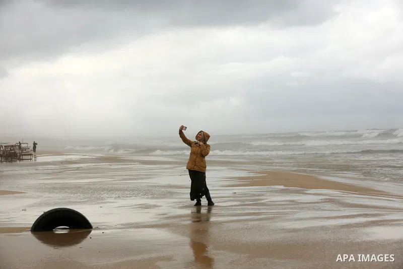 Palestinians show as they in their daily lives during a rainy day, in Gaza City December 01, 2021. A low-pressure front is expected to affect Palestine today, thus weather conditions are set to be partly cloudy to cloudy...