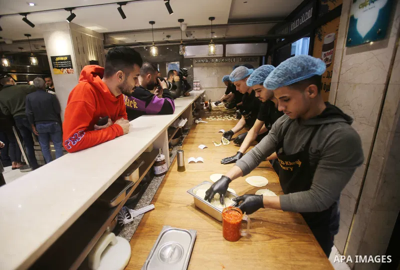 Palestinian workers prepar pastries to sell to customers in a bakery, in Gaza city, on December 2021. According to a report issued by the Palestinian Central Bureau of Statistics, the unemployment rate in the Gaza Strip...