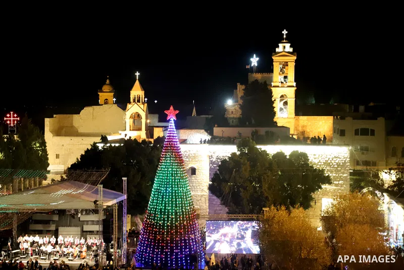 Palestinians light Christmas tree in Manger Square outside the Church of the Nativity in the West Bank city of Bethlehem on December 4, 2021. Christmas is an annual festival commemorating the birth of Jesus Christ, obser...