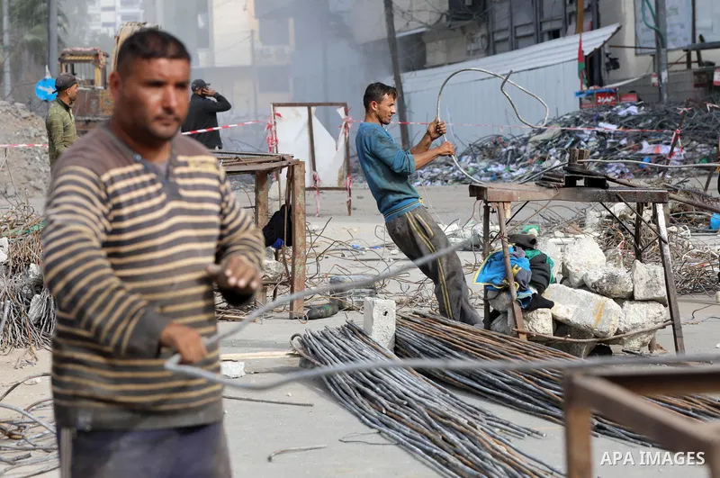 Palestinian workers remove the rubbles of al-Jawhara tower which was hit by Israeli strikes during the recent 11-day conflict between Israel and Hamas on May, in Gaza city on December 06, 2021. People and businesses in t...