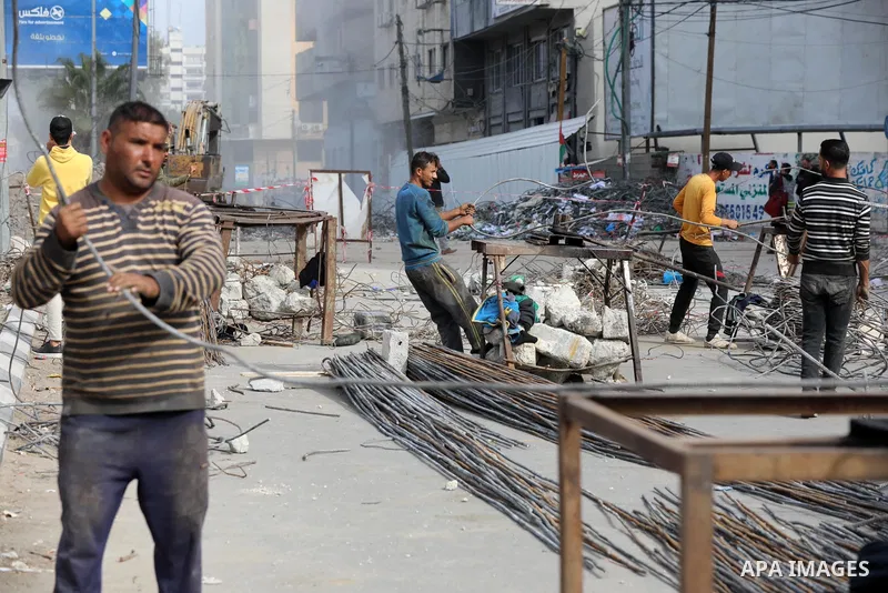 Palestinian workers remove the rubbles of al-Jawhara tower which was hit by Israeli strikes during the recent 11-day conflict between Israel and Hamas on May, in Gaza city on December 06, 2021. People and businesses in t...