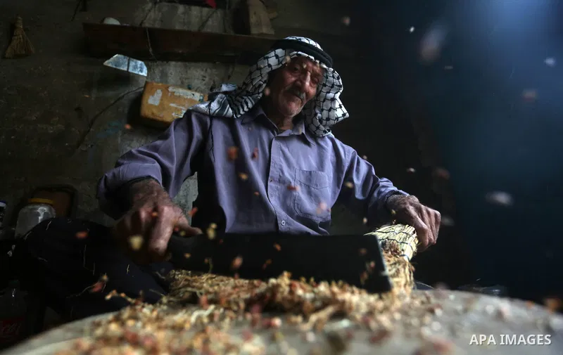 Palestinian man makes traditional straw brooms at his workshop in Roujeeb village, east of the West Bank city of Nablus, on December 8, 2021. A broom (also known in some forms as a broomstick) is a cleaning tool consisti...